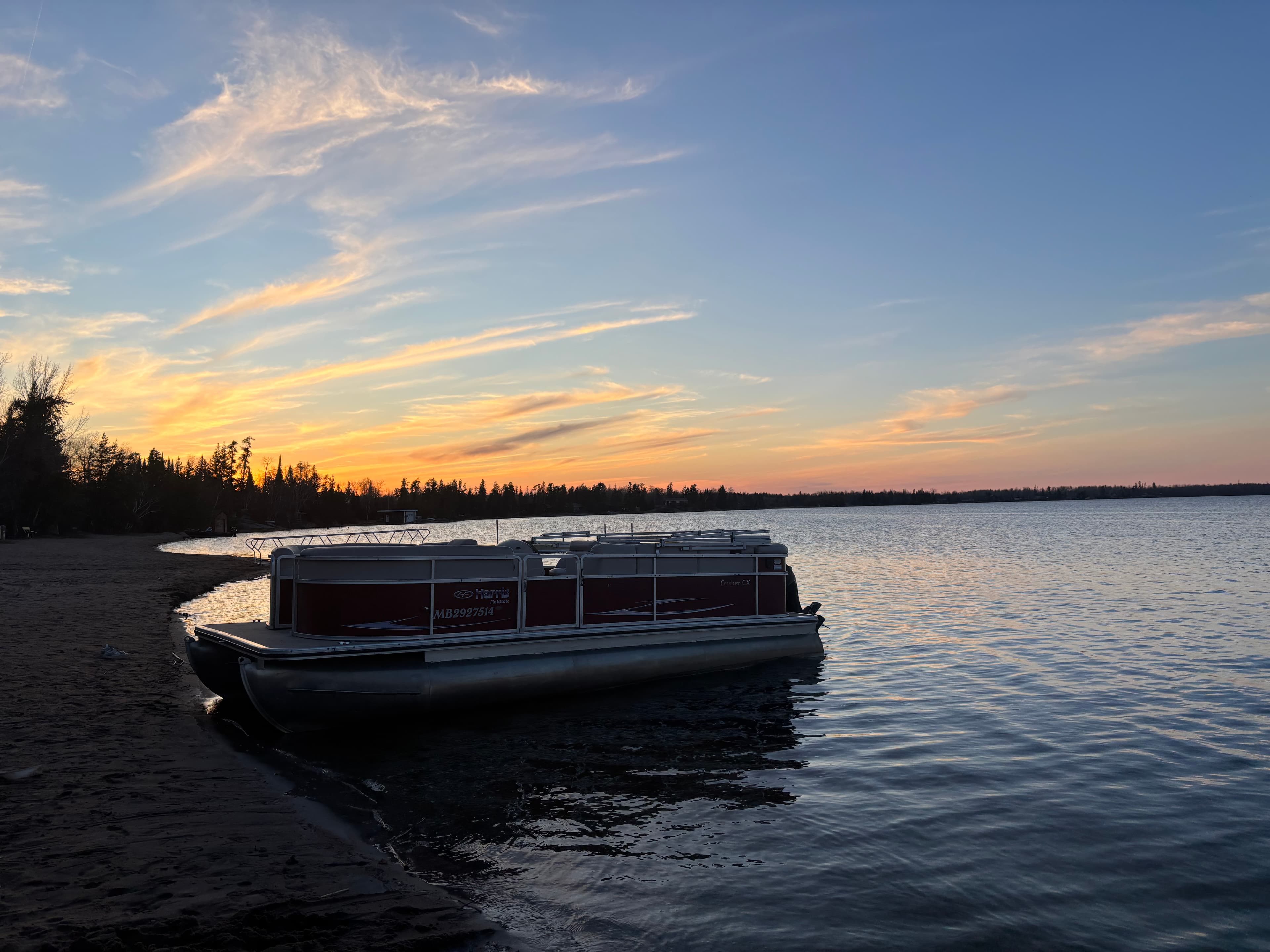Pontoon boat tied up at the Betula Lake dock at sunset